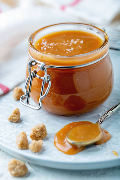 istock Salted caramel in a jar on a white plate. 1061831512