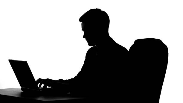 istock Businessman silhouette working on laptop computer, typing report, technologies 1061832120