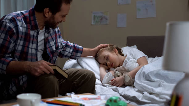 istock Caring father reading story book and daughter falling asleep, tender attitude 1061832242