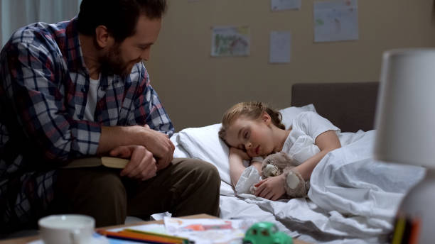 istock Loving father reading fairytale and daughter falling asleep, tender attitude 1061832264