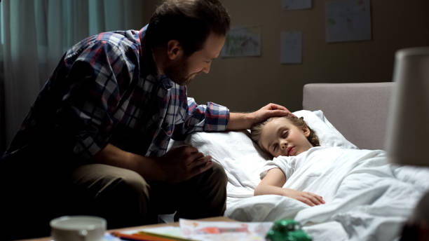 istock Happy father stroking sleeping daughter head love, admiring child, parenthood 1061832330