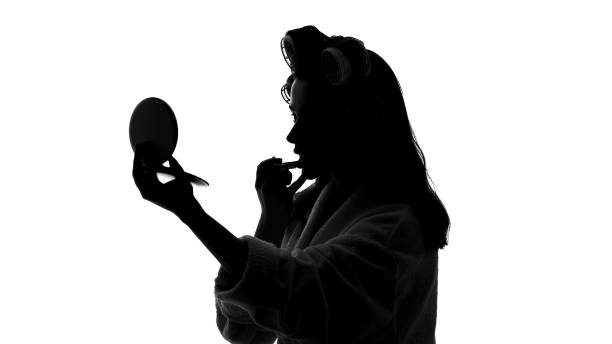 istock Pretty lady looking in mirror and applying lipstick, preparing for meeting 1061832998