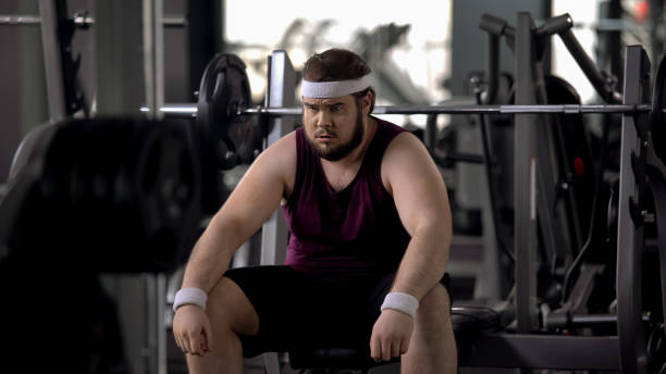 istock Tired fat man thinking over weight problems, desire to lose weight, gym workout 1061833052