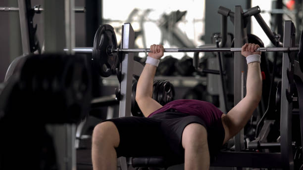 istock Fat man lifting up barbell, personal workout plan, desire to be strong and slim 1061833056