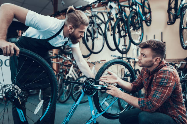 istock Two Guys Examine Bicycle in Sport Workshop 1061839312