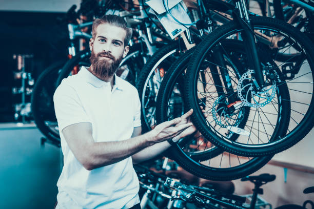istock Handsome Young Man Shows Row of Modern Bicycles 1061839320