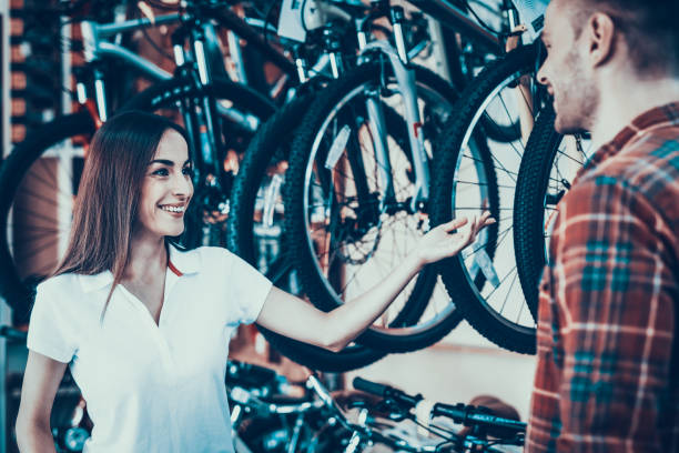 istock Consultant Shows Cycle to Customer in Sport Store 1061839362