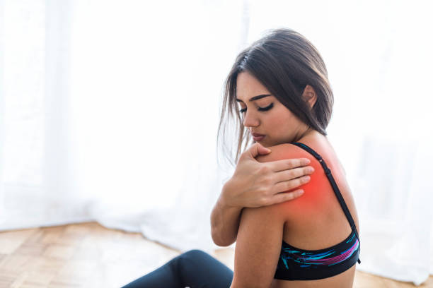 istock Sportswoman with painful face expression grabbing her shoulder. 1061841194