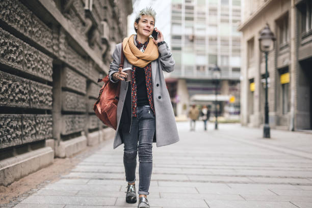 istock Hipster girl talking on a mobile phone while walking through a city 1061842502