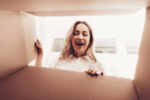 istock Smiling Woman Looks into Empty Box from Inside. 1061845262