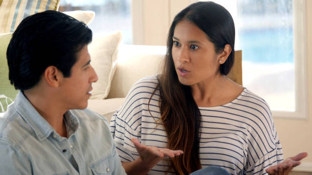 istock Man looks at his wife as she uses her hands to emphasize 1061845426