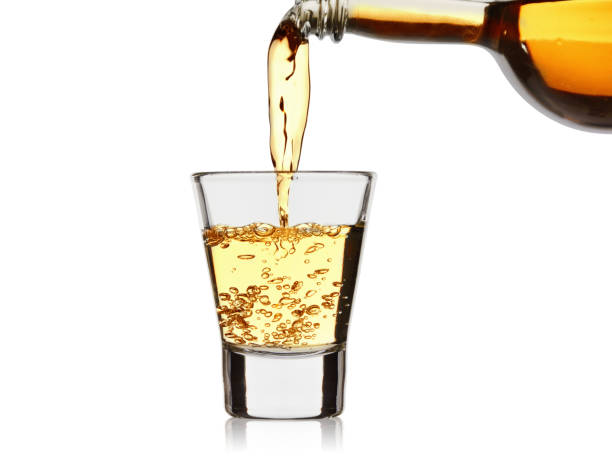 istock strong alcoholic drink pour from a bottle into a wineglass isolated on a white background 1061846064