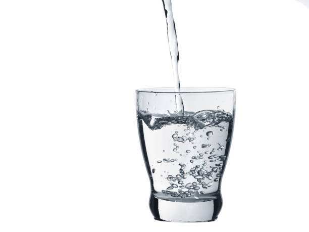 istock Water is poured into a glass isolated on white 1061847986