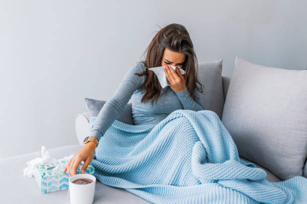 sick woman with headache sitting under the blanket - sick girl imagens e fotografias de stock