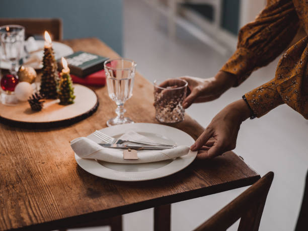 istock Woman setting the Christmas table preparing for dinner party 1061851156