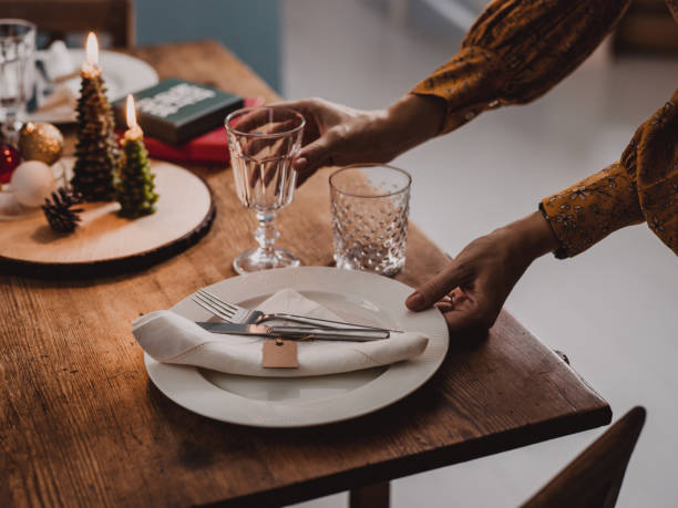istock Woman setting the Christmas table preparing for dinner party 1061852612