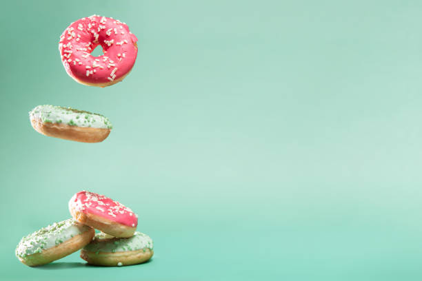 istock Donuts with pink and green icing with sprinkles on mint backround with copyspace for your text 1061858756
