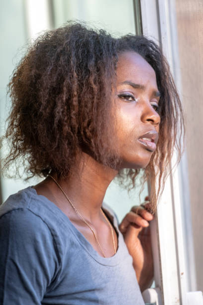 istock Serious young beautiful black woman looking through a window 1061864234