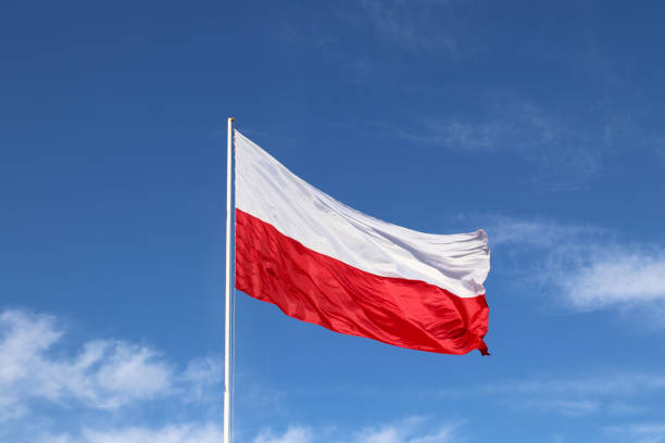 istock White-red horizontal flag on a flagpole developing in the wind against a blue sky with light clouds. Symbol of the Polish state. 1061865032