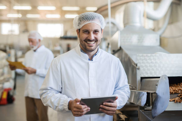 istock Smiling young technologist using tablet. Food factory interior. 1061868576
