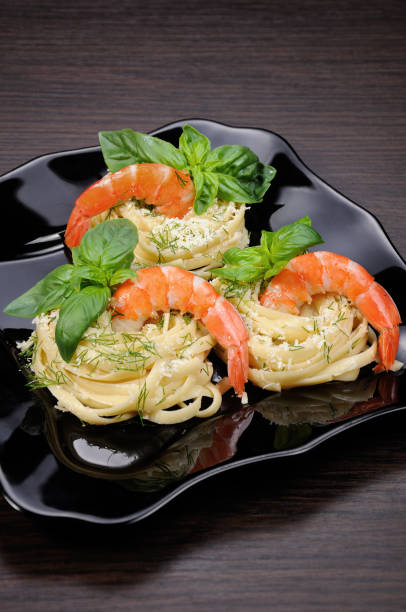 パルメザン チーズ ディル、エビとバジル風味のスパゲッティの巣。 - carbohydrate diabetes pasta food ストックフォトと画像