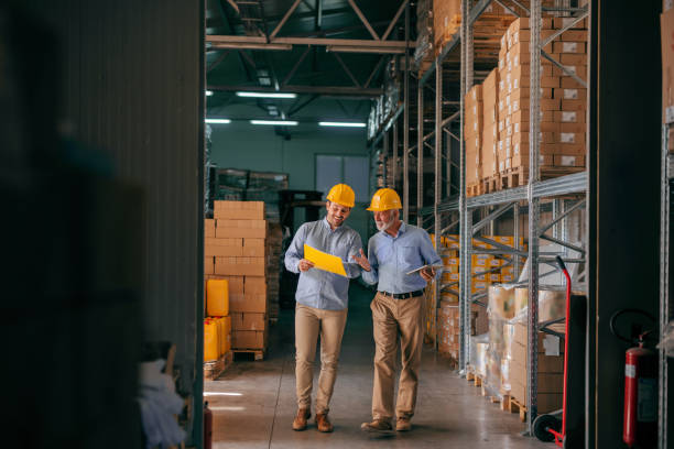 istock Colleagues walking in storage and checking documentation, on heads helmets. 1061871154