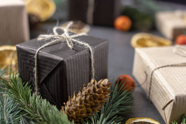 istock Christmas gift boxes with pine branches and dried oranges on dark texture surface. 1061871188