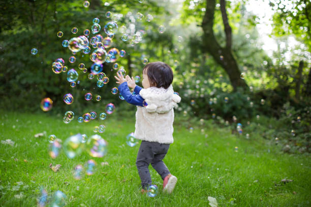istock baby girl play bubble at Spring garden 1061871640
