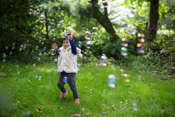 istock baby girl play bubble at Spring garden 1061871654