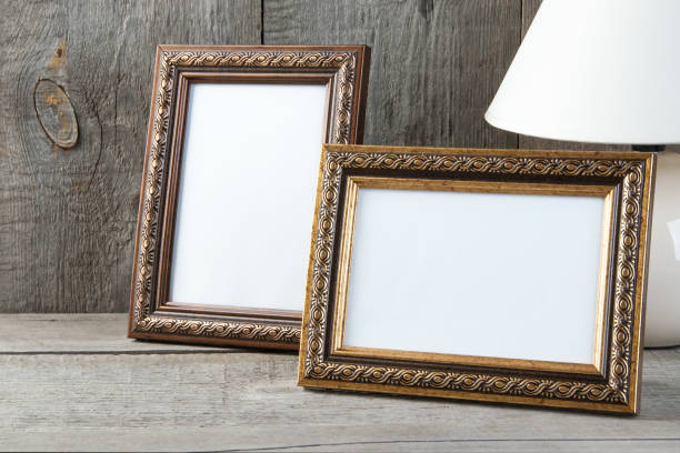 istock Two empty picture frames on wooden background. 1061882958