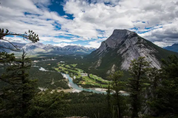 Lovely view from Tunnel Mountain summit in Banff National Park in Alberta Canada shows the Bow Valley below with its lush trees and a winding Bow River