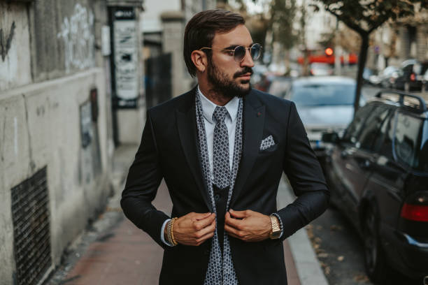 istock Handsome businessman walking on the sidewalk and buttoning jacket 1061888988