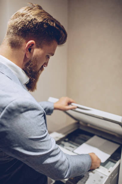 istock Beard Business man Hand press button on panel of printer, printer scanner laser office copy machine supplies start concept. 1061889468
