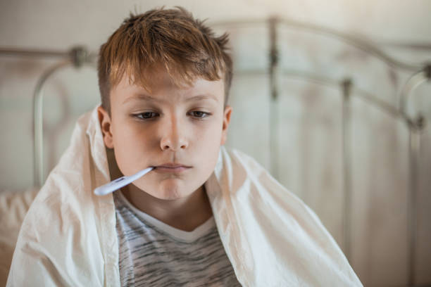istock Boy With a Thermometer in His Mouth 1061889876