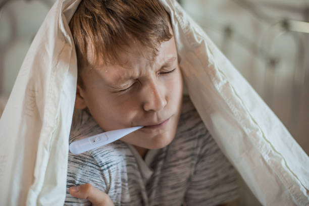 istock Boy With a Thermometer in His Mouth 1061889896