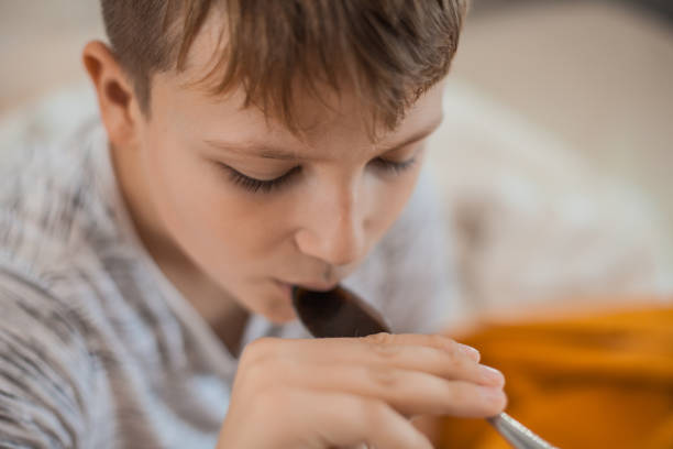 istock Young Boy Taking a Cough Syrup Medicine 1061889914
