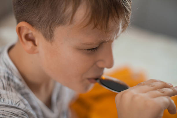 istock Young Boy Taking a Cough Syrup Medicine 1061889916