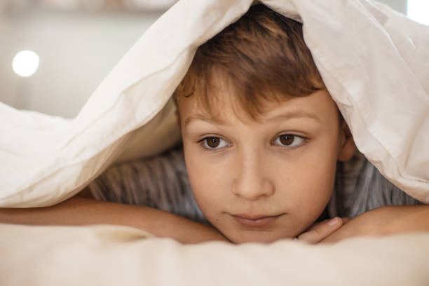 istock Cute Boy Covering Himself with a Blanket 1061893028