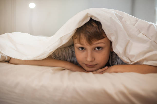 istock Cute Boy Covering Himself with a Blanket 1061893036