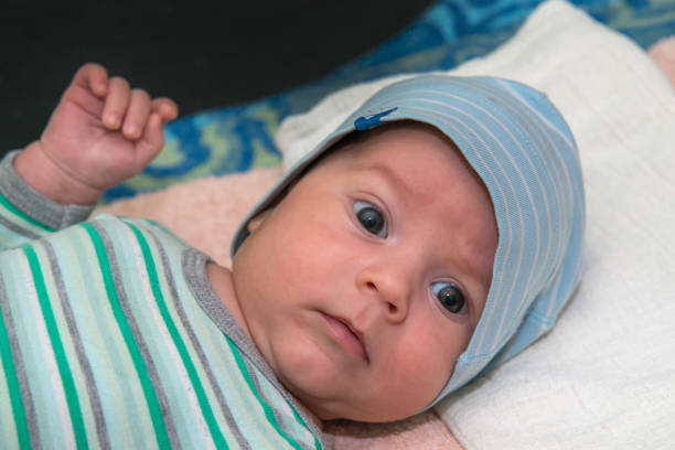 istock The newborn (2 months baby) with a hat is lying on the bed 1061898348