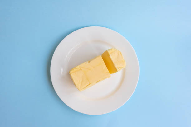 istock Organic butter on white plate from above on blue background 1061899740