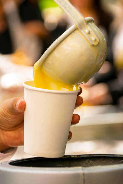 istock Latino person serving hot corn atol, typical guatemala drink, made with yellow corn, hot drink in disposable cup 1061903520