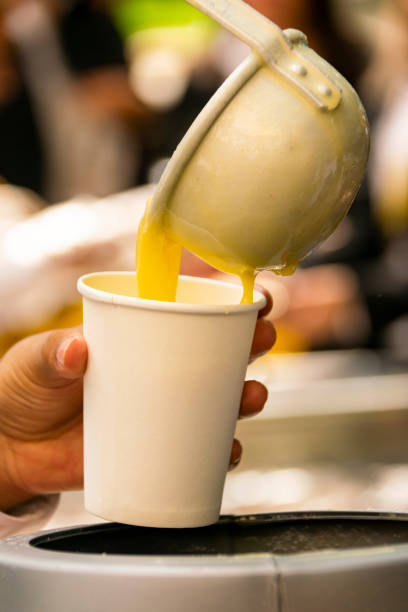 istock Latino person serving hot corn atol, typical guatemala drink, made with yellow corn, hot drink in disposable cup 1061903522