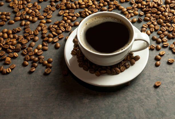 istock Coffee cup and beans with bright light on black rustic vintage table,Sparkling Coffee concept background. 1061923802