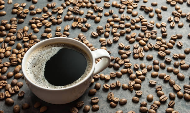 istock Coffee cup and beans with bright light on black rustic vintage table,Sparkling Coffee concept background. 1061925236