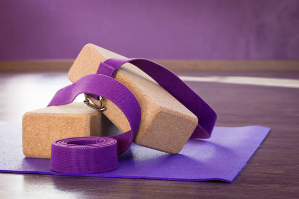 istock Cork bricks, purple strap and mat on yoga studio wooden floor 1061925562