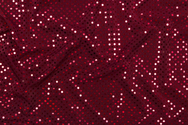 Dark red fabric with sparkling metallic dots design stock photo