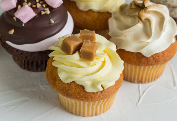 istock Gourmet cup cakes on textured background close up photo 1061944836