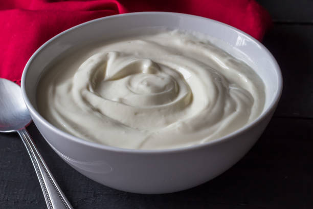 istock Yogurt in bowl on rustic black table - Greek yogurt background 1061944908