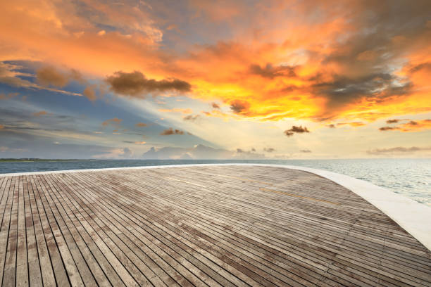 istock Wood square and dramatic sky with coastline at sunset 1061948424